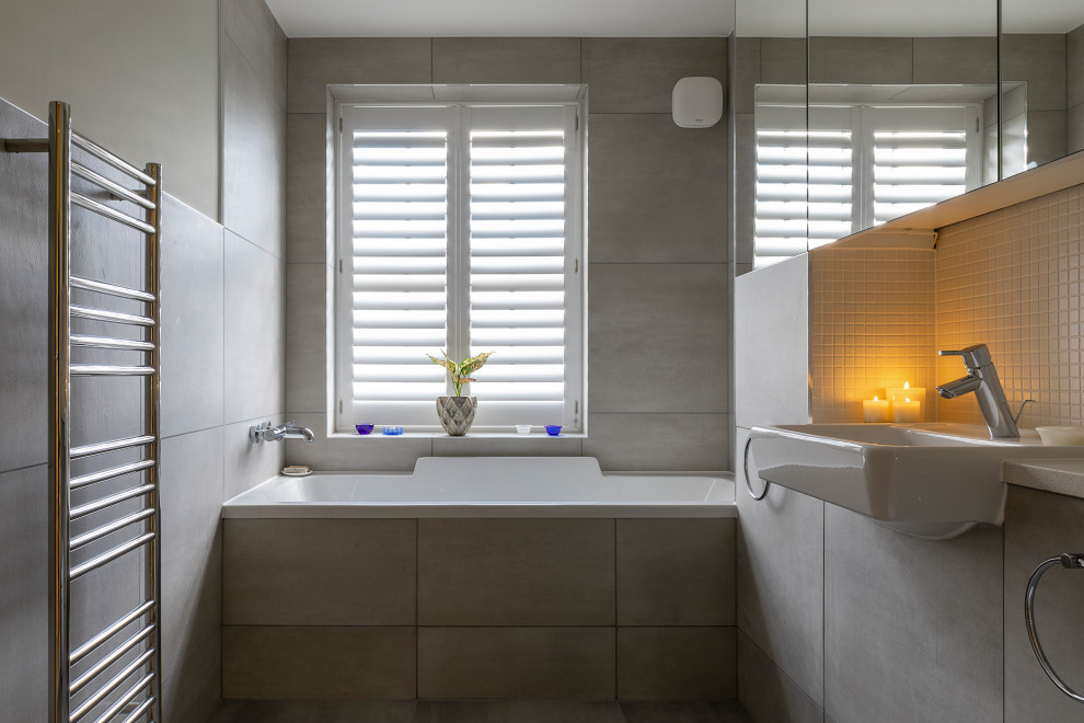 Photo of a medium sized classic bathroom in Oxfordshire with grey cabinets, a built-in bath, white walls, porcelain flooring, a built-in sink, tiled worktops, white floors, a built in vanity unit, a wallpapered ceiling and wallpapered walls.