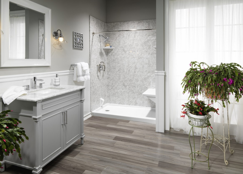 Cette image montre une grande salle d'eau minimaliste avec un placard à porte shaker, des portes de placard grises, un espace douche bain, un carrelage gris, un carrelage de pierre, un mur gris, un sol en carrelage imitation parquet, un lavabo encastré, un plan de toilette en quartz modifié, un sol marron, une cabine de douche avec un rideau, un banc de douche, meuble simple vasque, meuble-lavabo sur pied, un plafond voûté et boiseries.