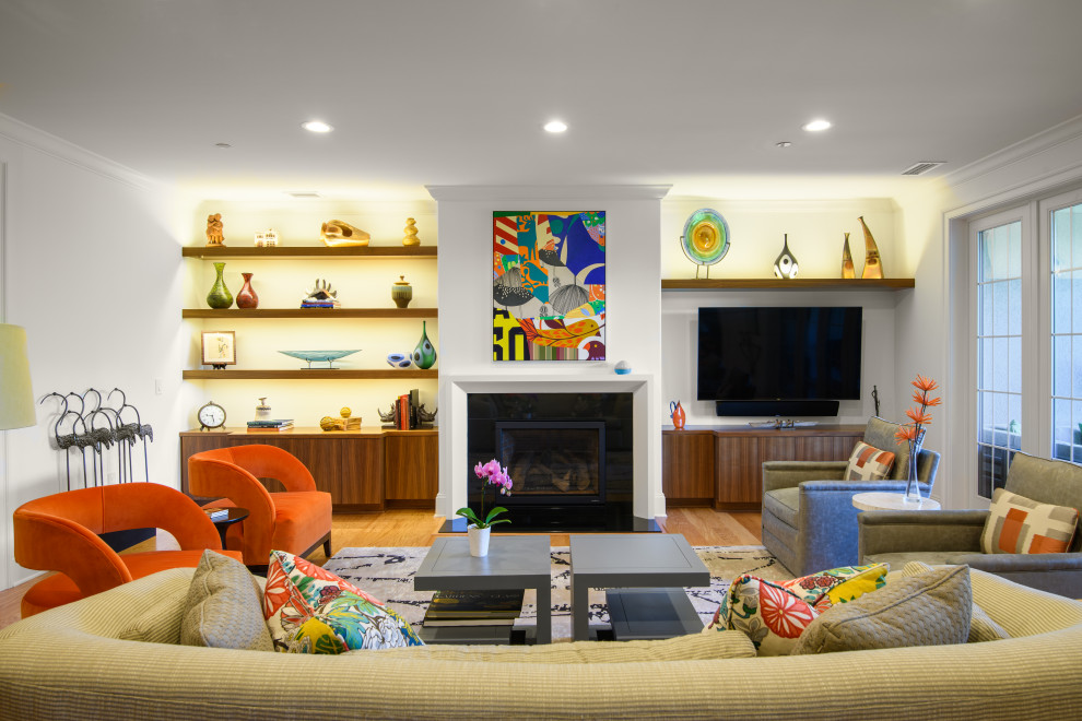 Imagen de salón abierto contemporáneo grande con paredes blancas, suelo de madera en tonos medios, televisor colgado en la pared y suelo marrón