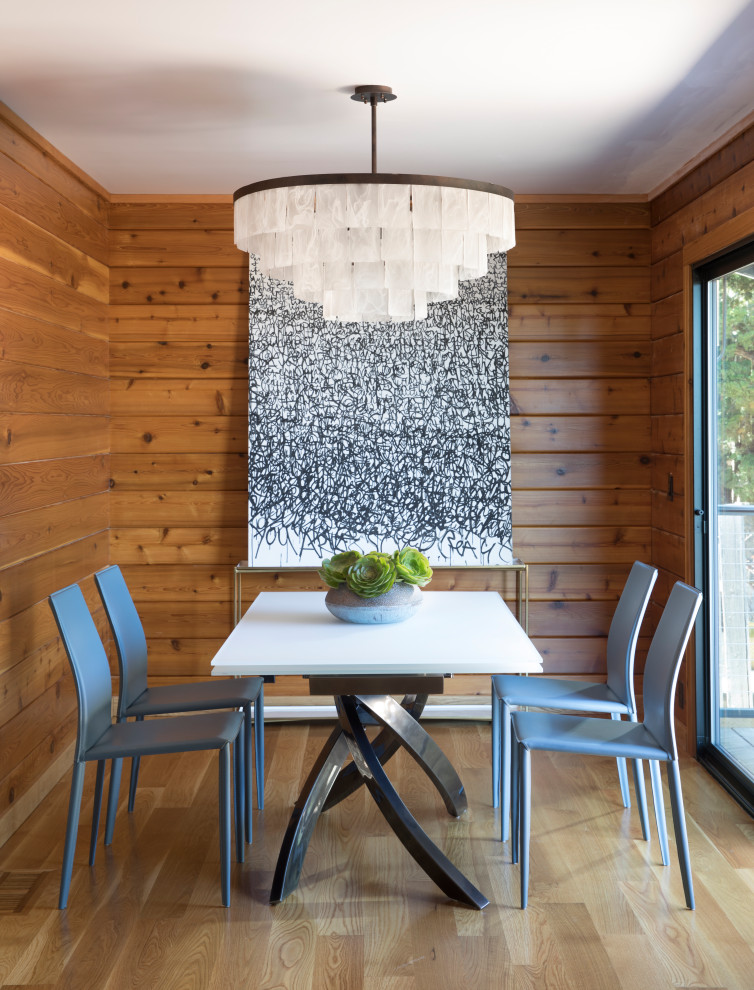 Immagine di una sala da pranzo minimal chiusa e di medie dimensioni con parquet chiaro e pareti in legno