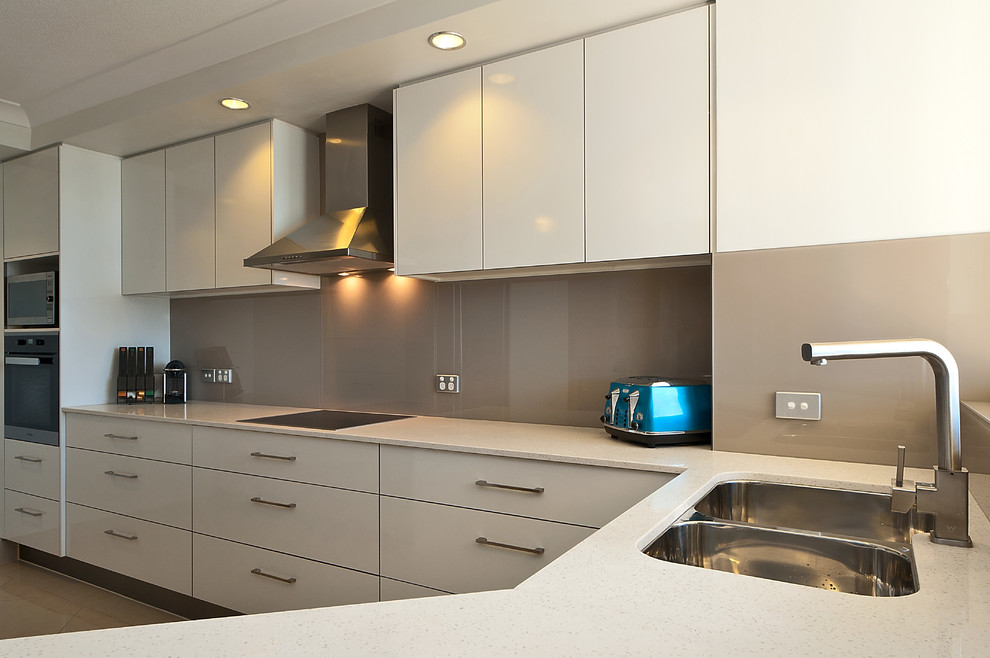 Design ideas for a small modern l-shaped separate kitchen in Gold Coast - Tweed with an undermount sink, flat-panel cabinets, white cabinets, quartz benchtops, grey splashback, glass sheet splashback, stainless steel appliances, ceramic floors and no island.
