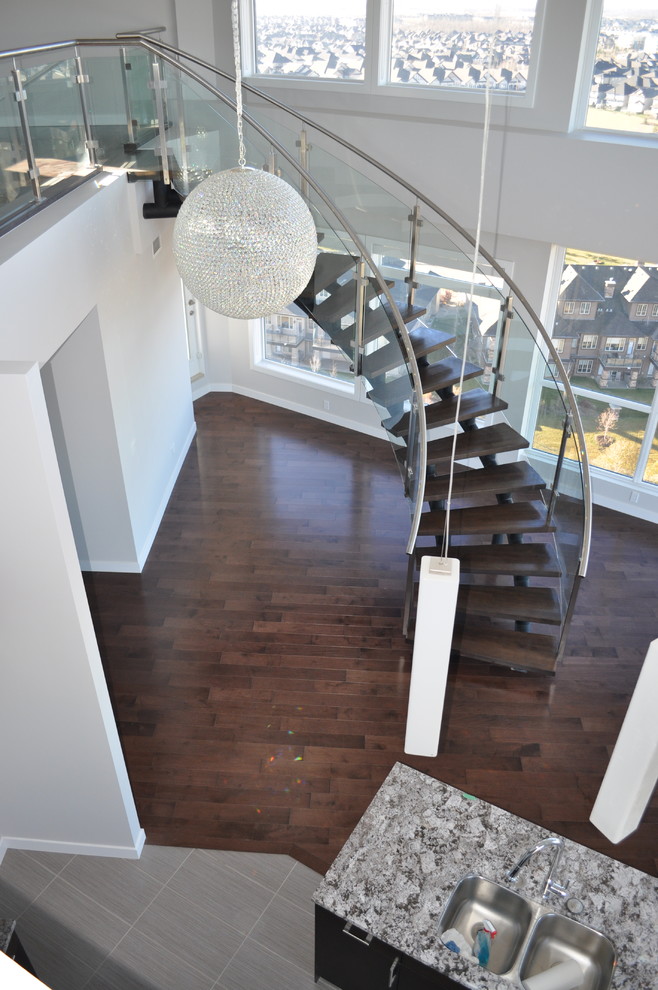 Photo of a mid-sized modern wood curved staircase in Edmonton with open risers.
