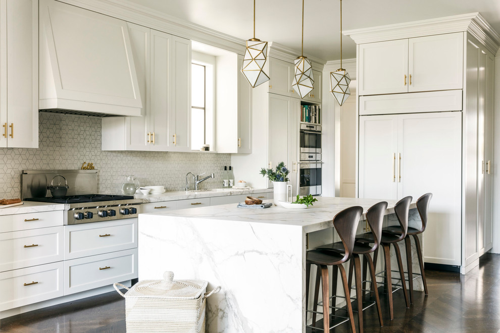 Inspiration for a transitional l-shaped kitchen in San Francisco with an undermount sink, shaker cabinets, white cabinets, white splashback, mosaic tile splashback, stainless steel appliances, dark hardwood floors, with island, brown floor and white benchtop.