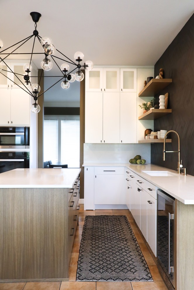 This is an example of a mid-sized modern u-shaped eat-in kitchen in Austin with an undermount sink, flat-panel cabinets, white cabinets, quartz benchtops, black splashback, porcelain splashback, panelled appliances, ceramic floors, with island, brown floor and white benchtop.