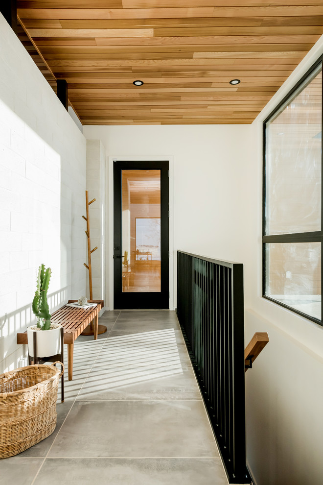 Midcentury hallway in Other with white walls, ceramic floors and grey floor.