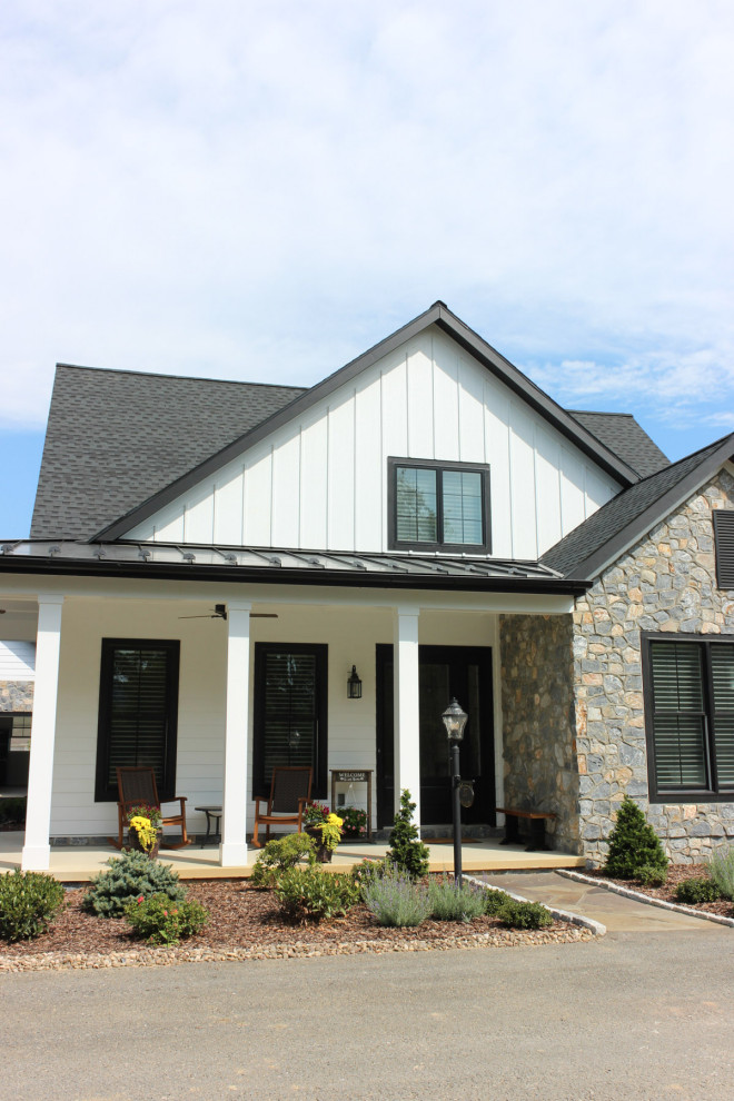 Country two-storey white house exterior in Nashville with a shingle roof and board and batten siding.