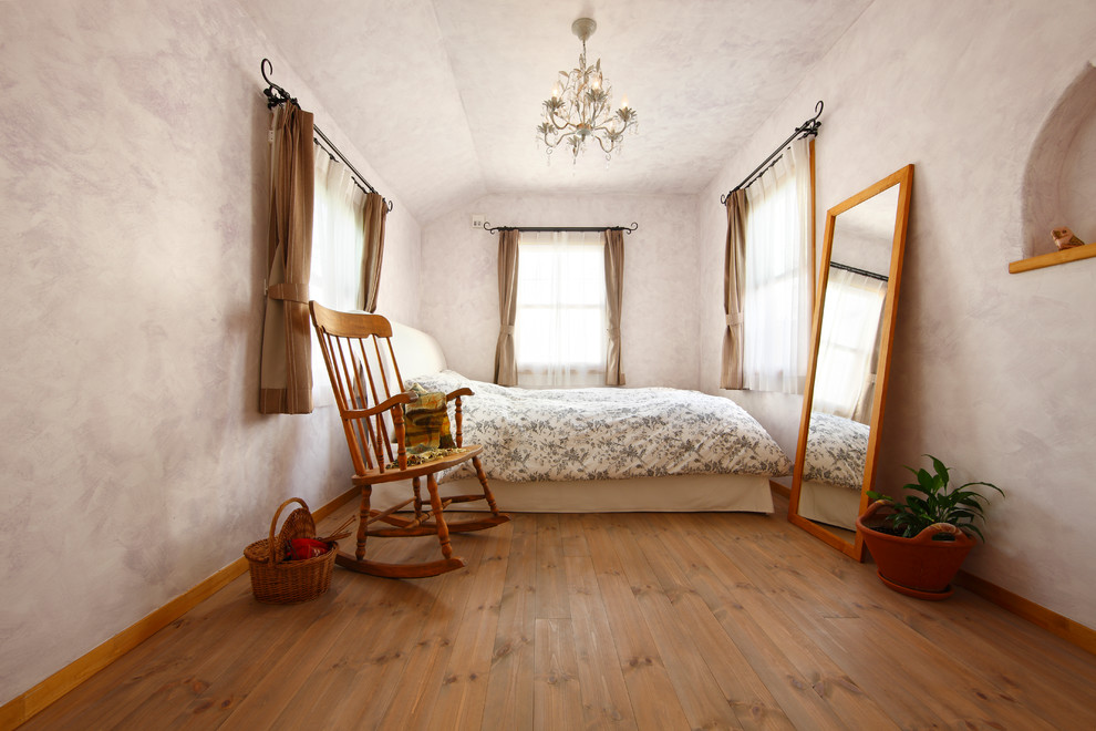 Photo of a transitional bedroom in Other with pink walls, medium hardwood floors and brown floor.
