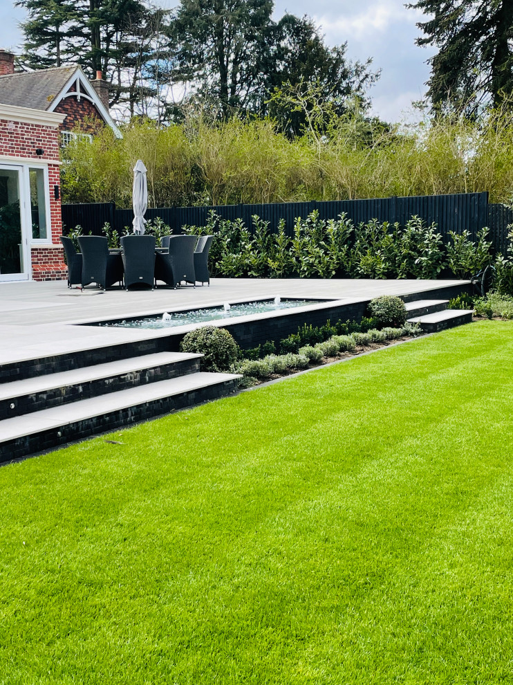 Idee per un grande giardino formale minimalista esposto a mezz'ombra dietro casa in estate con pedane e recinzione in legno