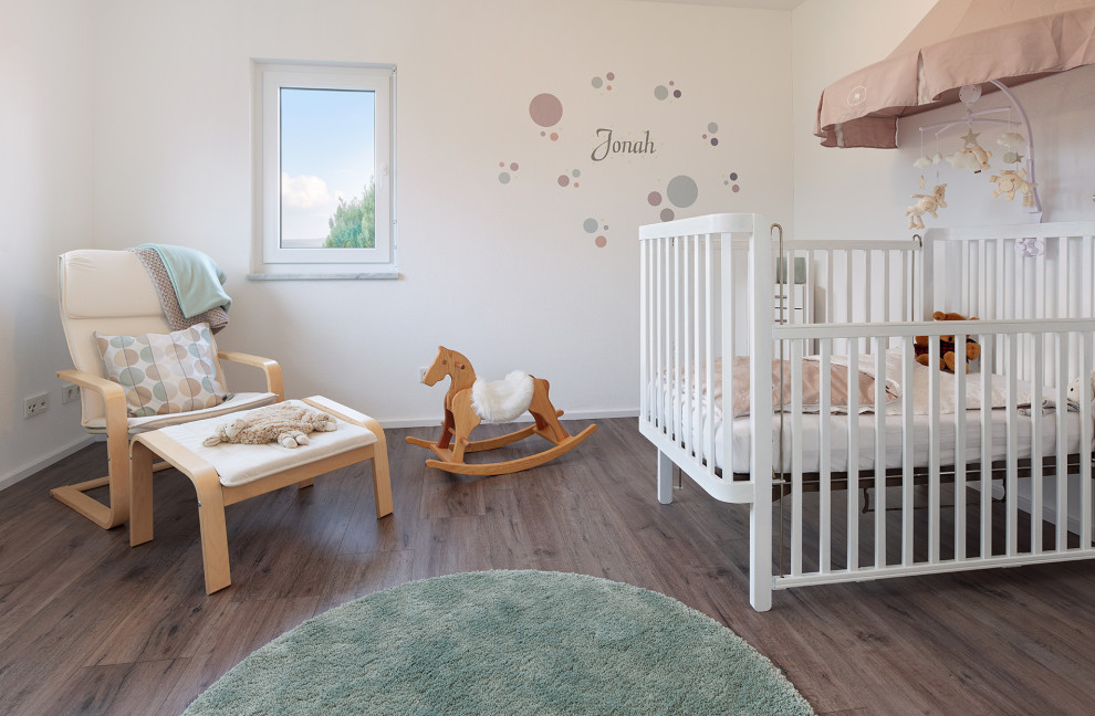 Expansive traditional nursery with brown floor.