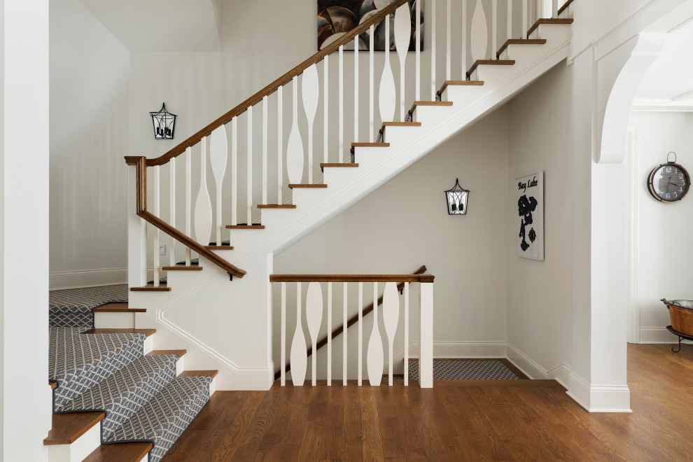 Design ideas for a large nautical wood u-shaped wood railing staircase in Minneapolis with painted wood risers.