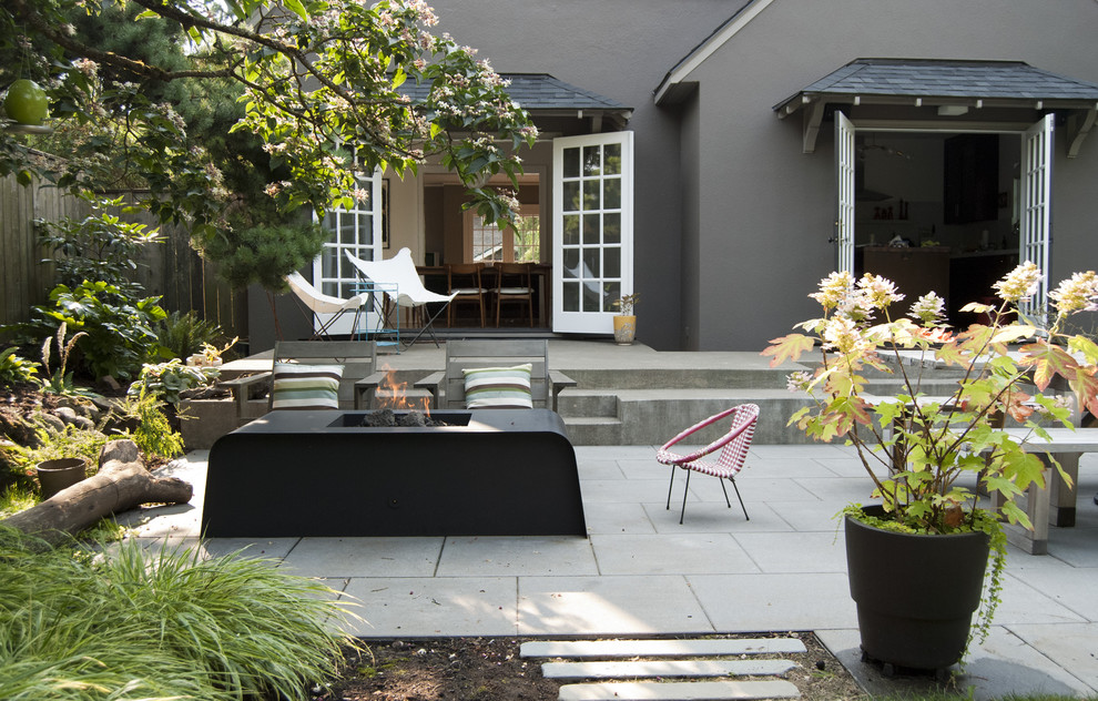 Contemporary backyard patio in Portland with a fire feature and concrete pavers.