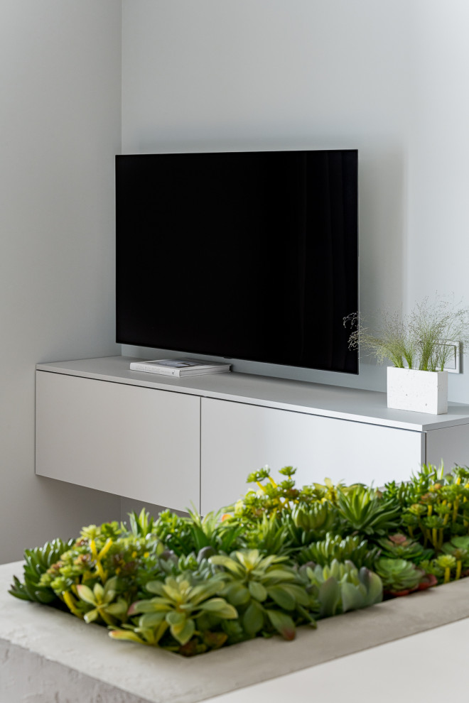 Bild på ett mellanstort funkis allrum, med grå väggar och en väggmonterad TV