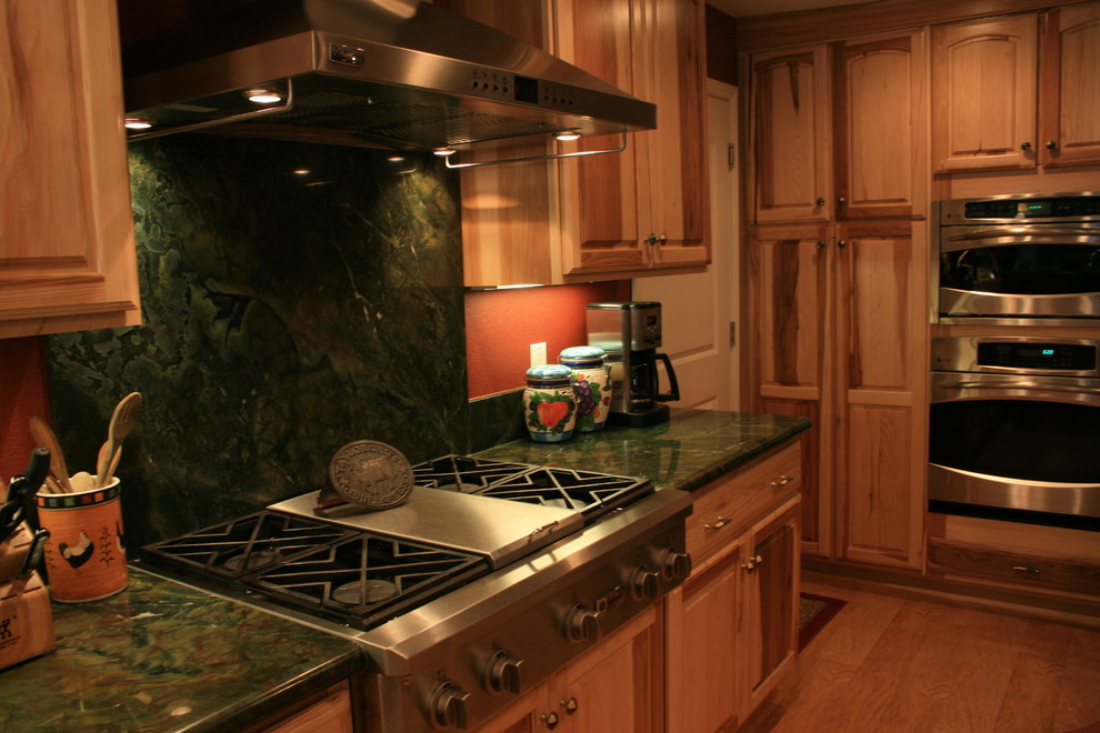 Mid-sized mountain style u-shaped eat-in kitchen photo in Sacramento with an undermount sink, raised-panel cabinets, light wood cabinets, granite countertops, green backsplash, stone slab backsplash, stainless steel appliances and an island