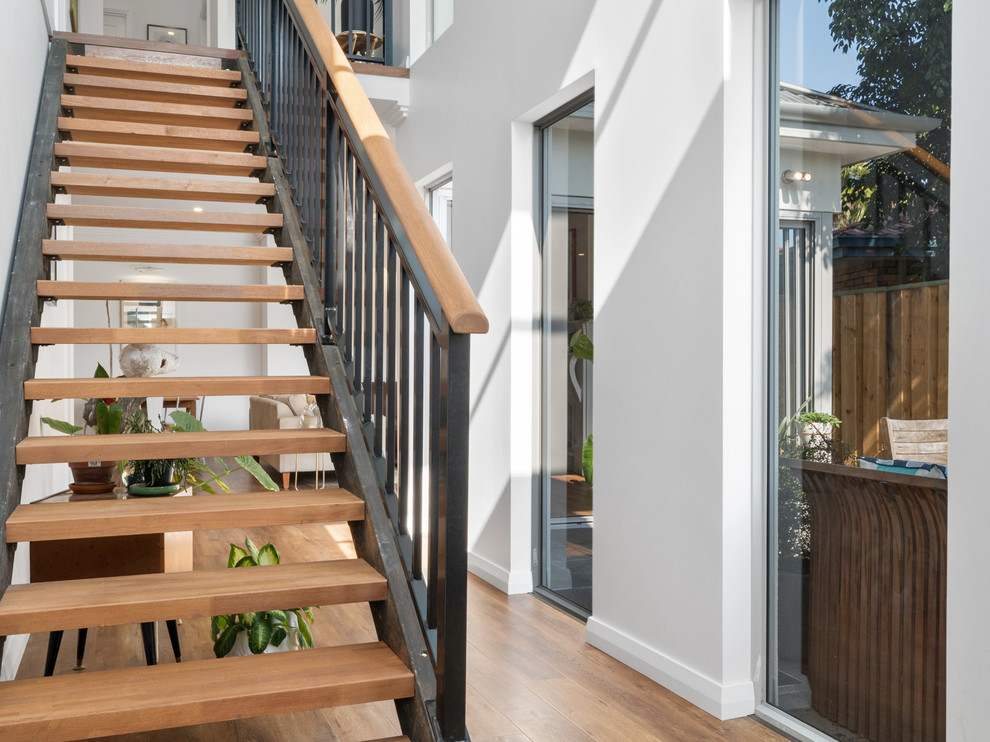 This is an example of a small contemporary wood straight staircase in Perth with metal risers and metal railing.