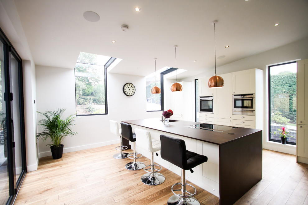 Inspiration for a contemporary grey and white open plan kitchen in Cheshire with an island.