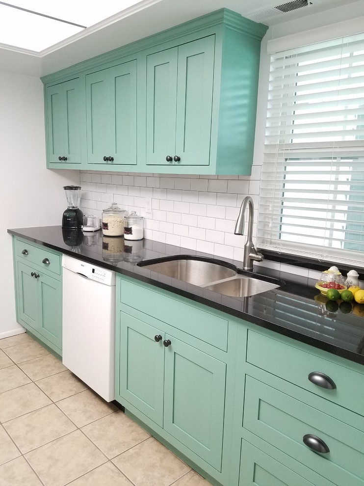 Eat-in kitchen - small transitional galley porcelain tile and beige floor eat-in kitchen idea with a double-bowl sink, shaker cabinets, green cabinets, granite countertops, black backsplash, subway tile backsplash, white appliances and no island