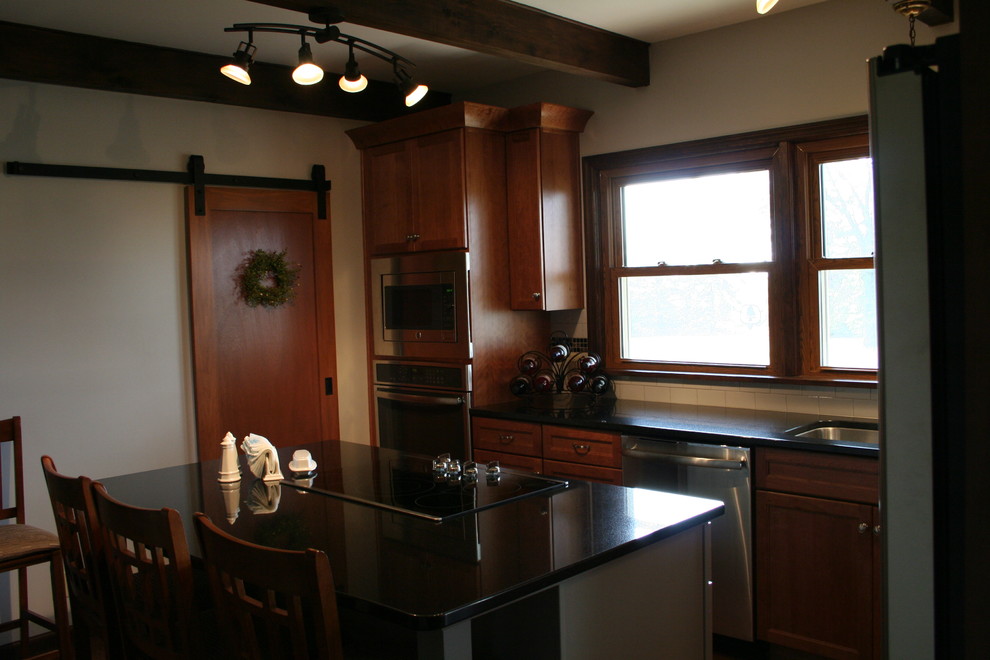 Kitchen - mid-sized transitional l-shaped medium tone wood floor kitchen idea with an undermount sink, medium tone wood cabinets, granite countertops, white backsplash, subway tile backsplash, stainless steel appliances, an island and recessed-panel cabinets