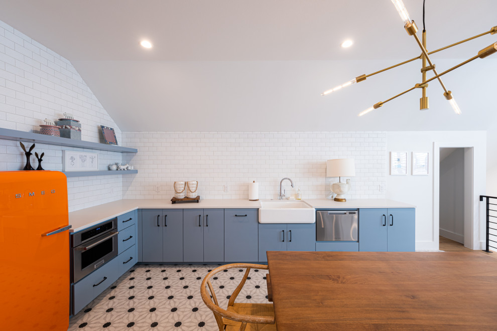 Inspiration for a mid-sized eclectic l-shaped open plan kitchen in Austin with a farmhouse sink, flat-panel cabinets, blue cabinets, quartzite benchtops, white splashback, subway tile splashback, stainless steel appliances, cement tiles, multi-coloured floor, white benchtop and vaulted.