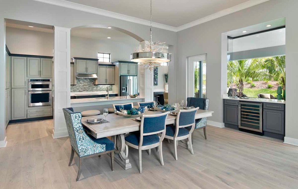 Design ideas for a mid-sized beach style kitchen/dining combo in Miami with beige walls, light hardwood floors and brown floor.