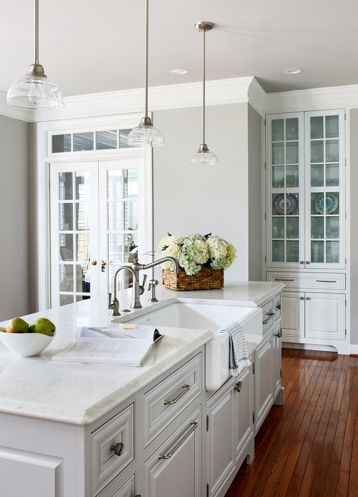 Inspiration for a large traditional single-wall eat-in kitchen in DC Metro with white cabinets, white splashback, panelled appliances, medium hardwood floors, with island and white benchtop.