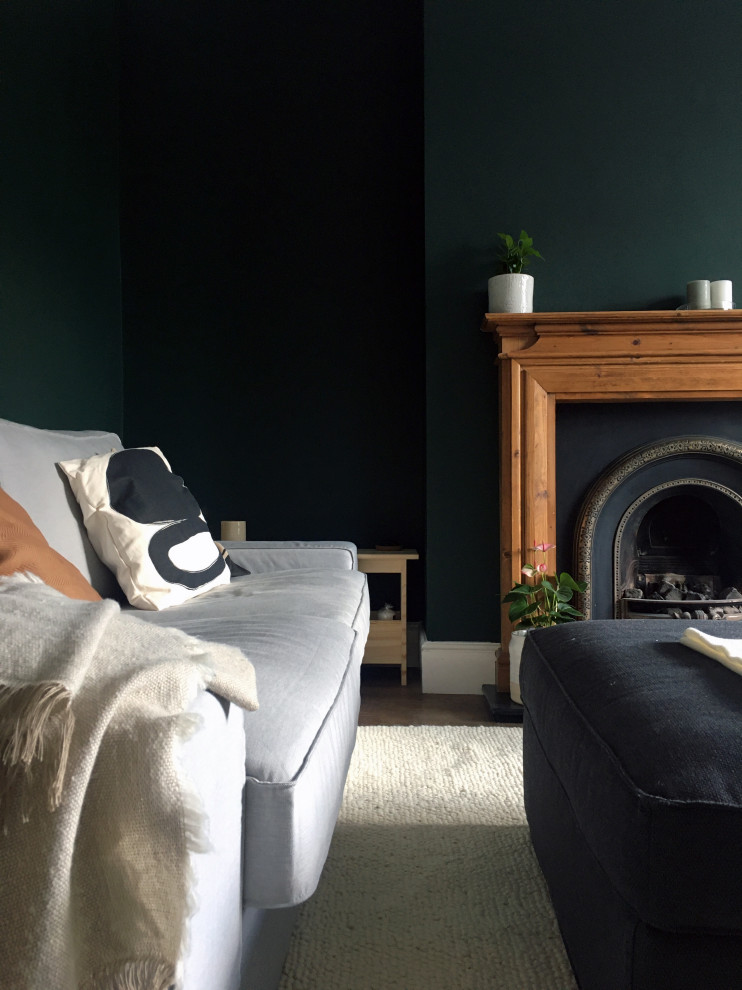 This is an example of a medium sized classic grey and cream living room in Other with green walls, dark hardwood flooring, a standard fireplace, a wooden fireplace surround, brown floors and a chimney breast.