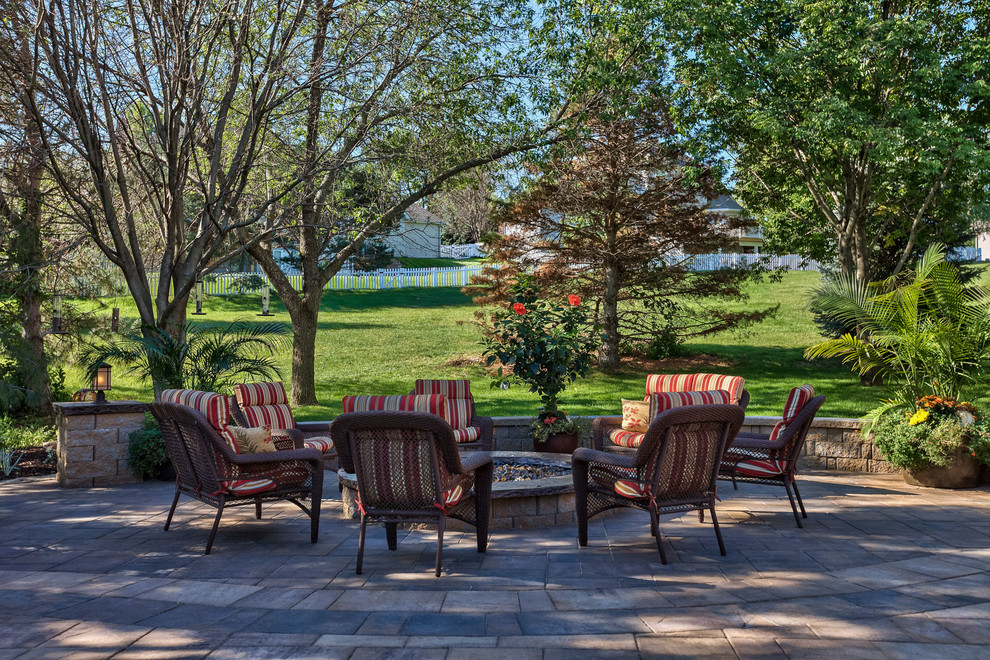 Inspiration for a large traditional backyard patio in Omaha with a fire feature and concrete pavers.