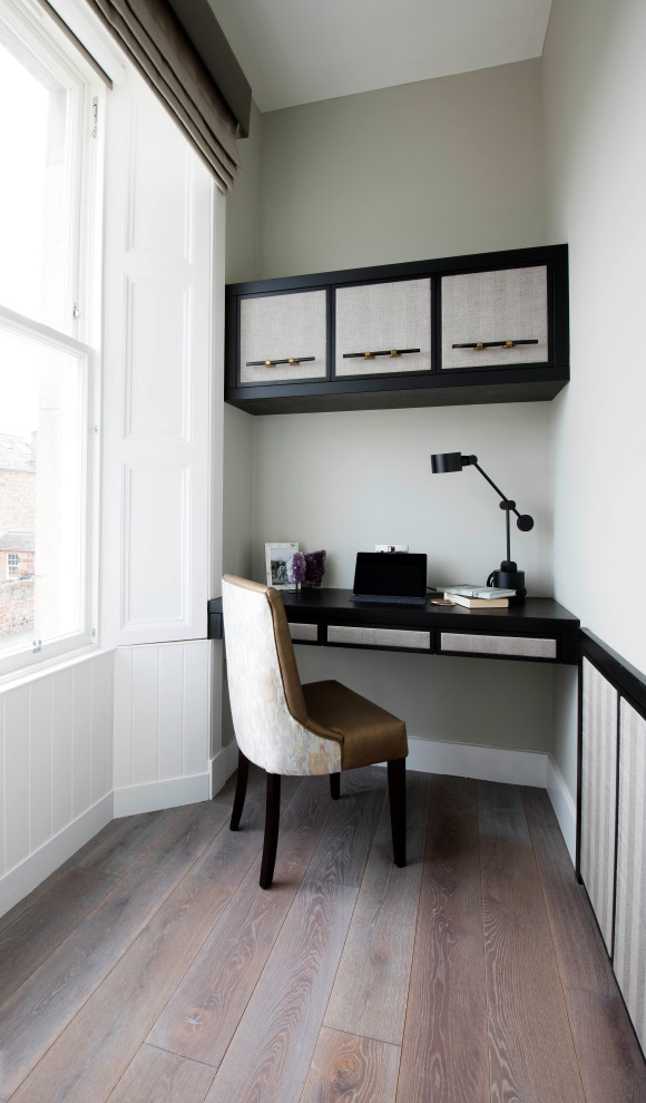 Inspiration for a transitional study room in Other with grey walls, medium hardwood floors, a built-in desk and brown floor.