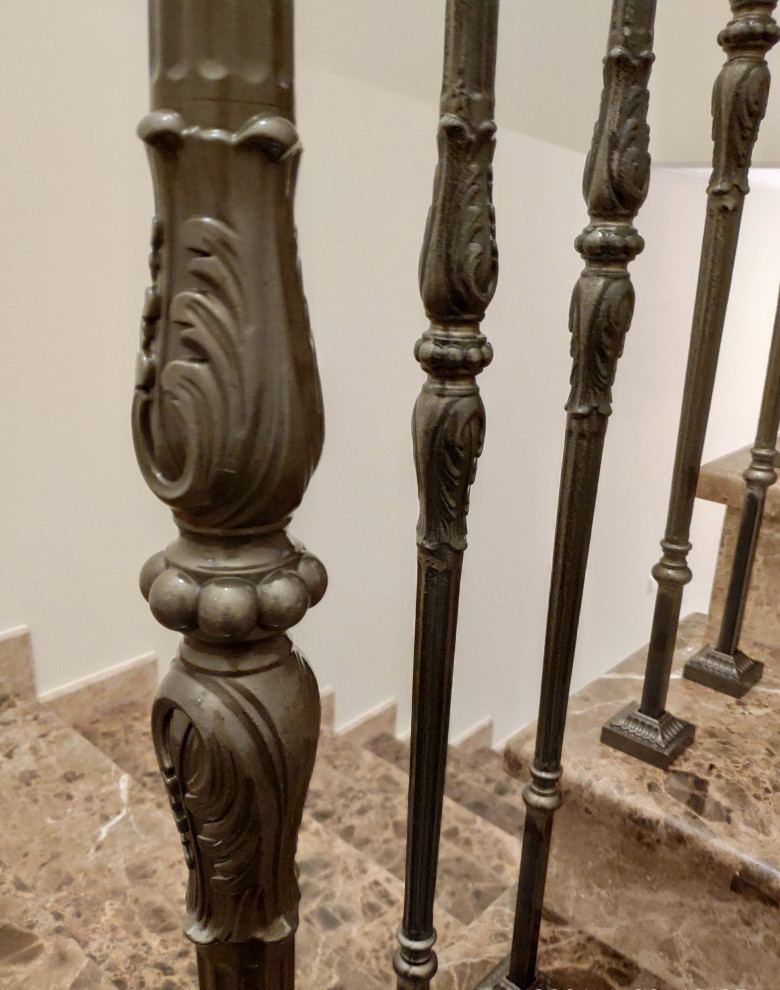 Modelo de escalera en U tradicional con escalones de mármol, contrahuellas de mármol y barandilla de metal