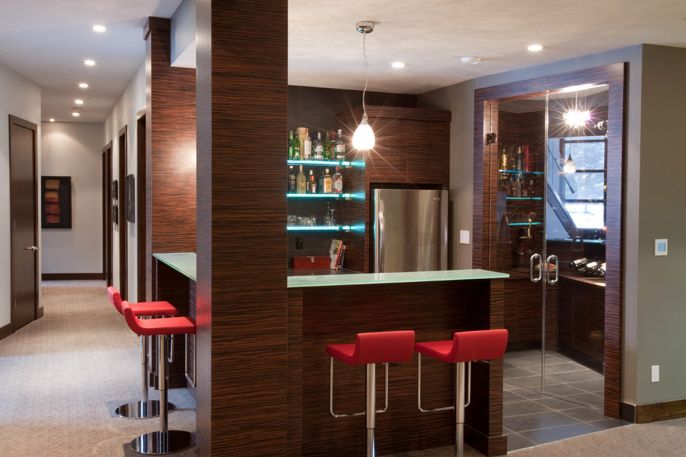 This is an example of a large contemporary single-wall seated home bar in Calgary with no sink, open cabinets, dark wood cabinets, glass benchtops, slate floors and grey floor.