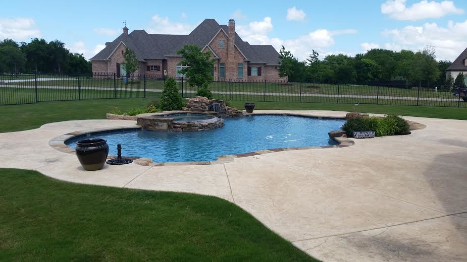 Inspiration for a mid-sized tropical backyard custom-shaped natural pool in Dallas with stamped concrete.