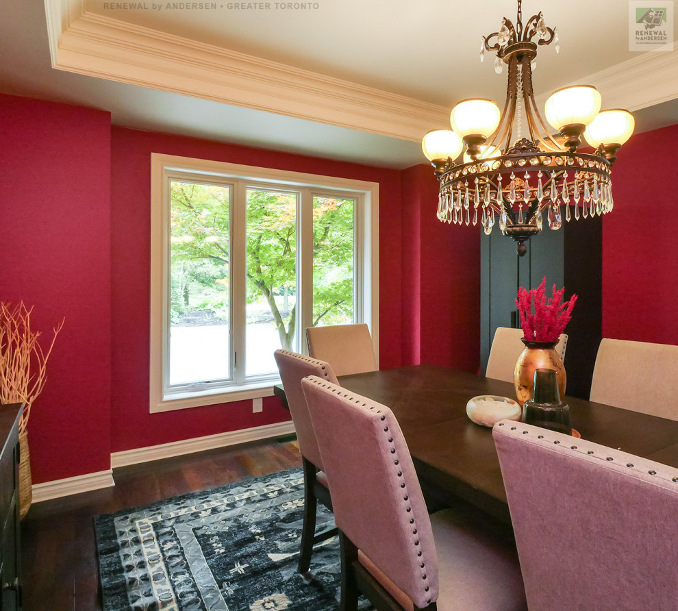 This is an example of a mid-sized separate dining room in Toronto with red walls, dark hardwood floors, no fireplace, multi-coloured floor and coffered.