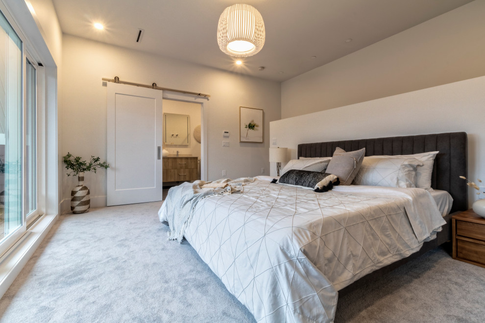 This is an example of a medium sized contemporary master bedroom in Vancouver with white walls, carpet and grey floors.