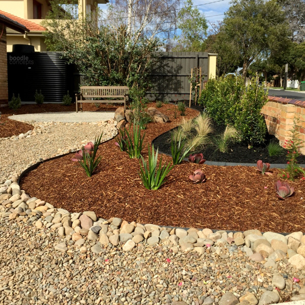 This is an example of a large modern front yard full sun formal garden for winter in Melbourne with a garden path and mulch.
