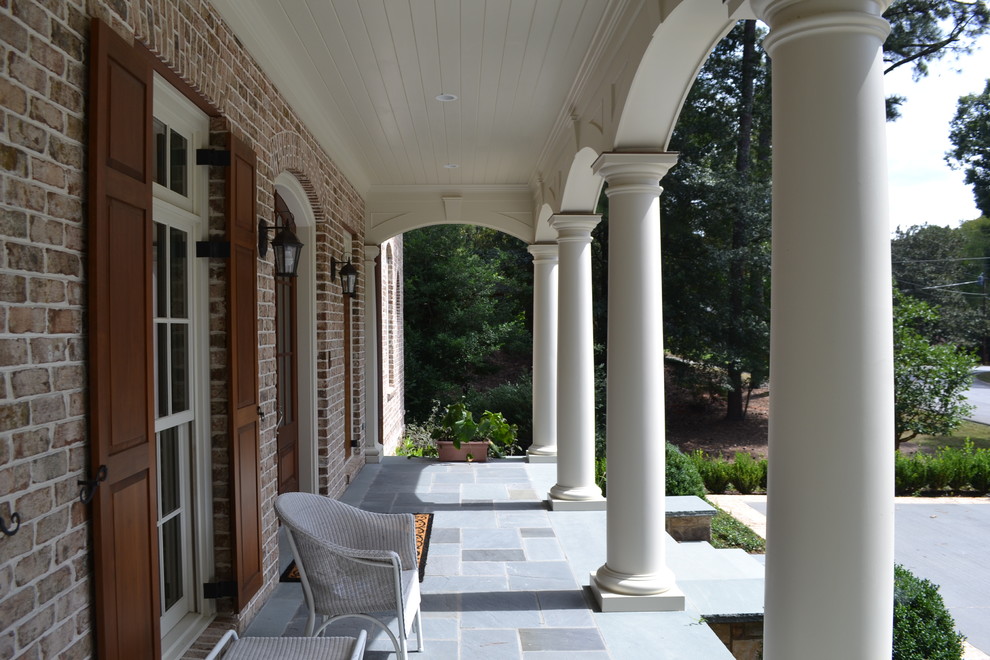Inspiration for a mid-sized traditional front yard verandah in Atlanta with tile and a roof extension.