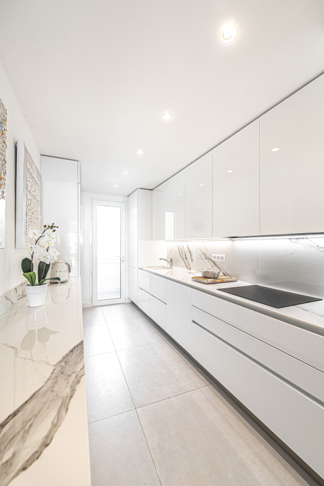 Design ideas for a mid-sized contemporary galley kitchen in Nice with an undermount sink, flat-panel cabinets, white cabinets, white splashback, panelled appliances, porcelain floors, no island, grey floor and white benchtop.