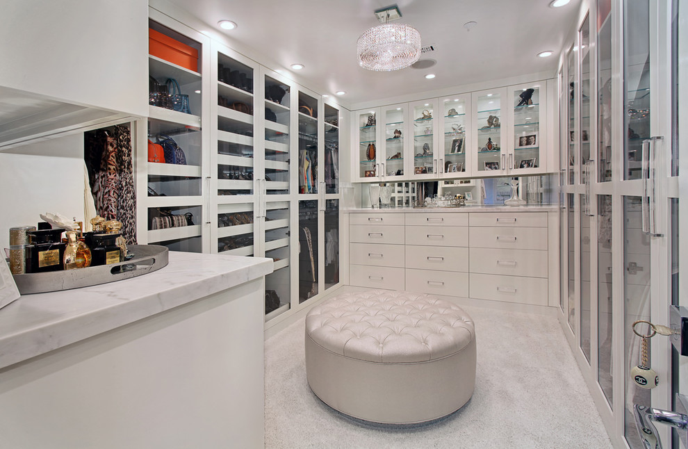 Large trendy gender-neutral carpeted dressing room photo in Orange County with glass-front cabinets and white cabinets