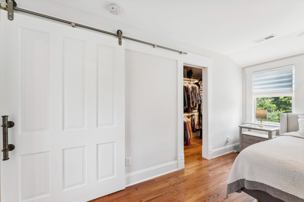 Idee per una camera matrimoniale chic di medie dimensioni con pareti bianche, pavimento in legno massello medio e pavimento marrone