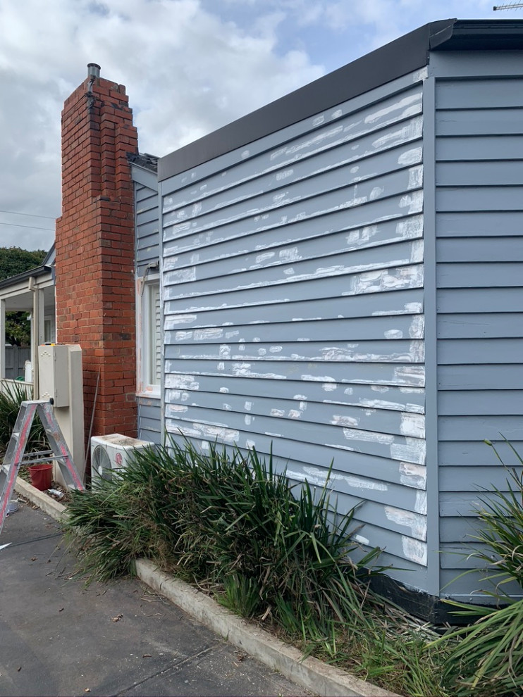 Photo of a small beach style one-storey house exterior in Melbourne with wood siding.