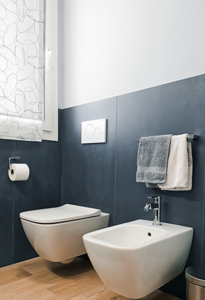 Inspiration for a small industrial blue tile and porcelain tile porcelain tile and brown floor powder room remodel in Bologna with a wall-mount toilet