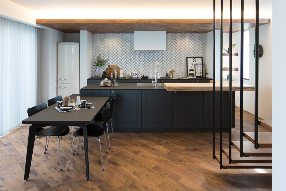 Design ideas for a contemporary single-wall open plan kitchen with an undermount sink, beaded inset cabinets, grey cabinets, black splashback, white appliances, medium hardwood floors, with island and brown floor.