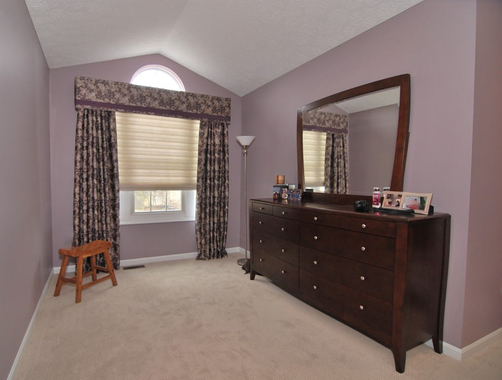This is an example of a large asian master bedroom in Philadelphia with purple walls, carpet, a standard fireplace, a wood fireplace surround and beige floor.