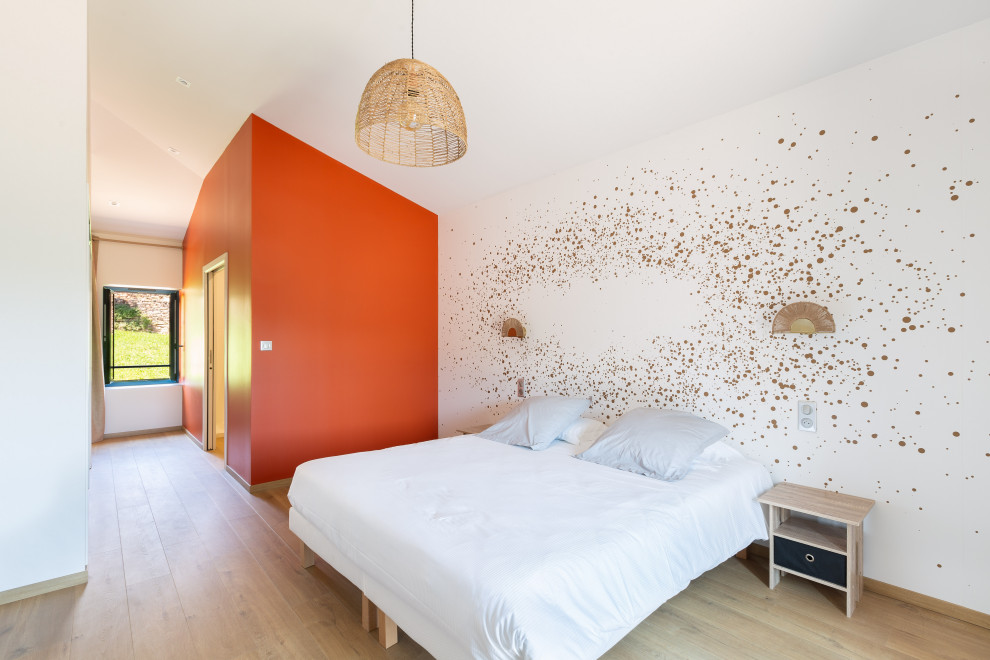 Großes Landhaus Hauptschlafzimmer mit weißer Wandfarbe, hellem Holzboden und Tapetenwänden in Dijon