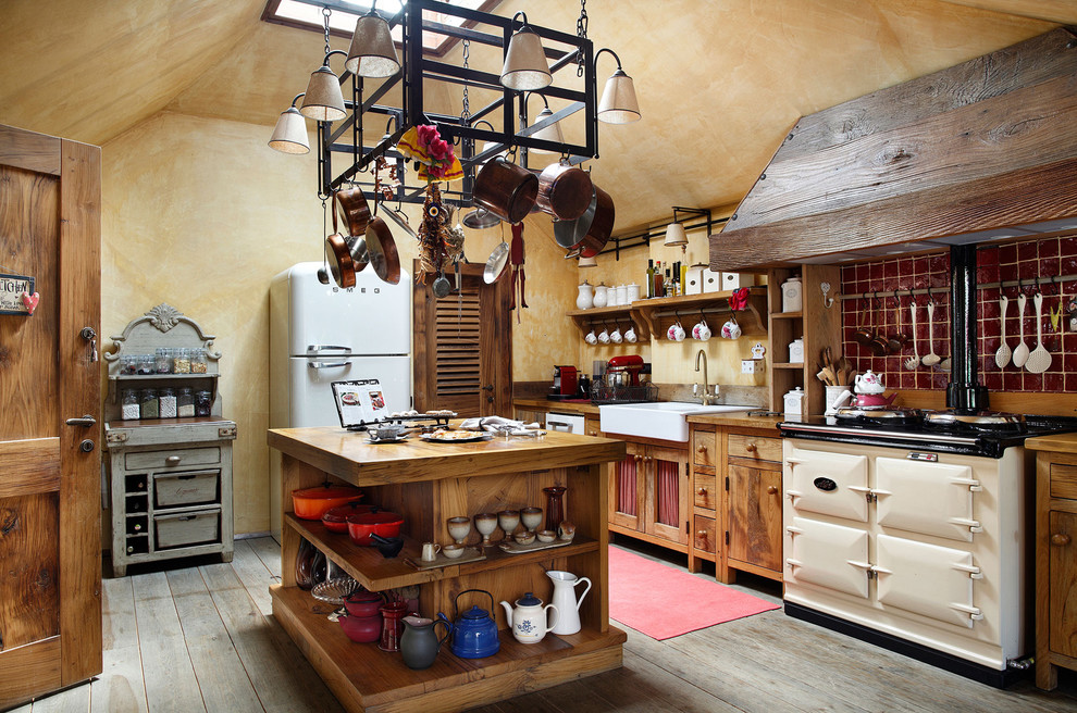 Photo of a country l-shaped separate kitchen in Other with a farmhouse sink, flat-panel cabinets, medium wood cabinets, wood benchtops, red splashback, ceramic splashback and white appliances.