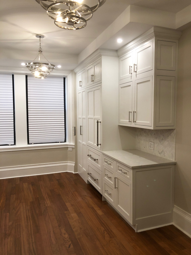 Inspiration for a small transitional galley dark wood floor and brown floor eat-in kitchen remodel in New York with an undermount sink, recessed-panel cabinets, white cabinets, quartz countertops, multicolored backsplash, marble backsplash, paneled appliances, no island and white countertops