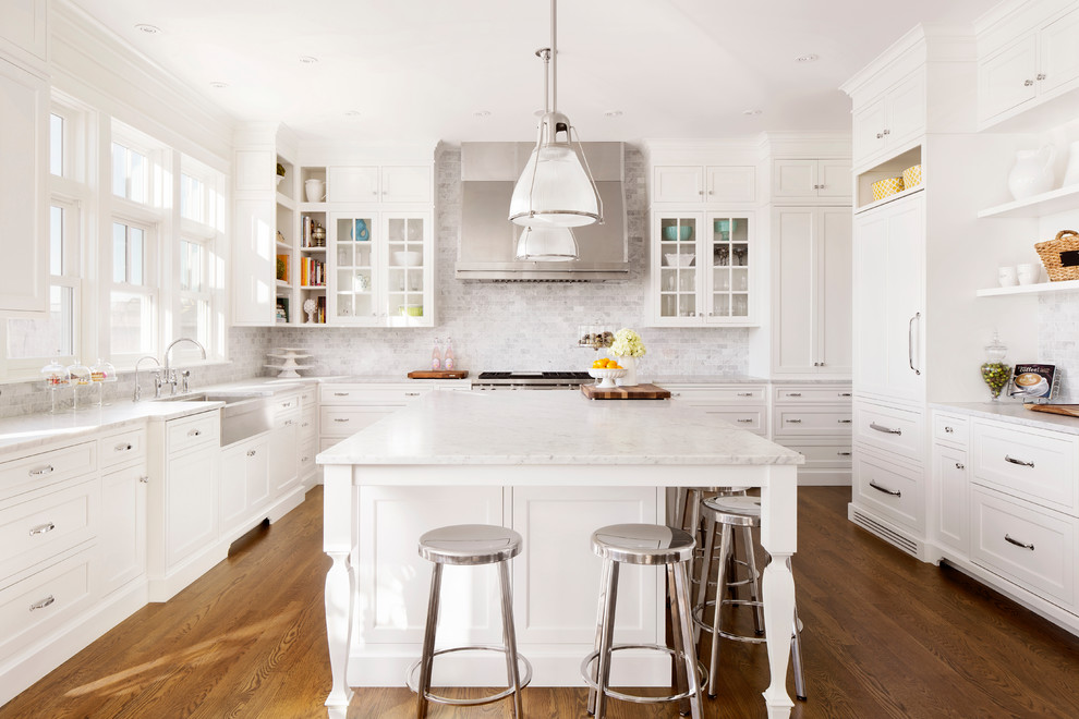 Inspiration for a traditional u-shaped kitchen in Calgary with shaker cabinets, white cabinets, white splashback, subway tile splashback, white appliances, medium hardwood floors, with island and brown floor.