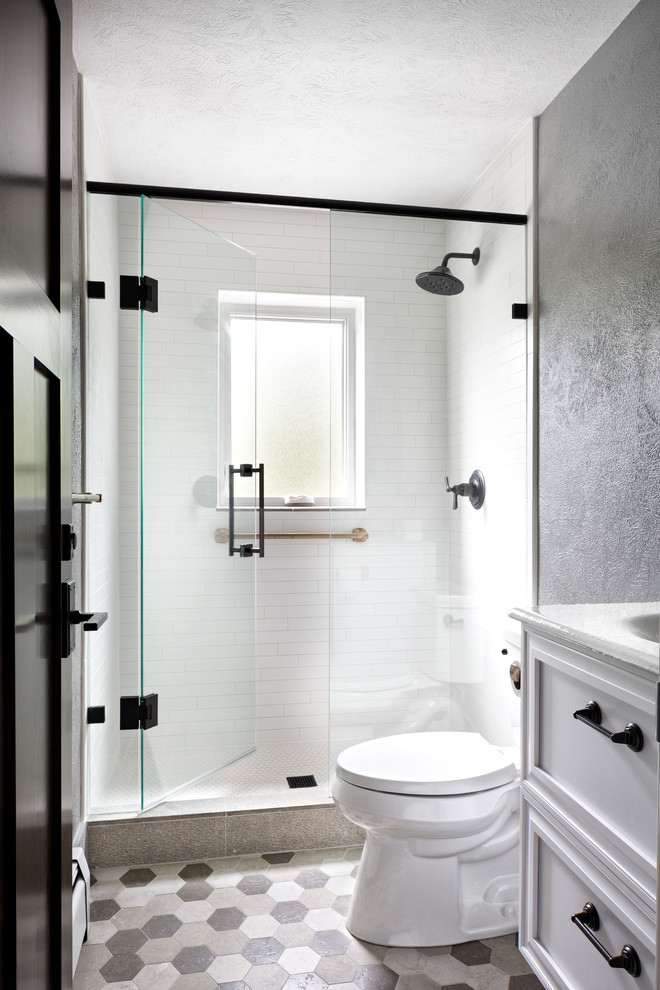 Alcove shower - mid-sized transitional 3/4 white tile and ceramic tile gray floor alcove shower idea in Denver with recessed-panel cabinets, white cabinets, a two-piece toilet, gray walls, an integrated sink and a hinged shower door