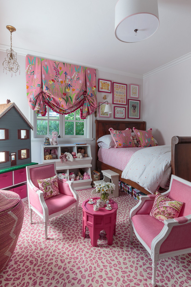 This is an example of a mid-sized transitional kids' bedroom for girls in San Francisco with pink walls and carpet.