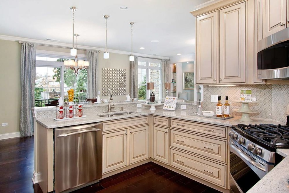 Eat-in kitchen - large transitional l-shaped dark wood floor eat-in kitchen idea in Chicago with a double-bowl sink, raised-panel cabinets, beige cabinets, quartz countertops, beige backsplash, ceramic backsplash, stainless steel appliances and a peninsula