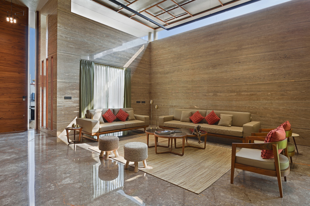 This is an example of a large asian living room in Mumbai with brown walls and brown floor.
