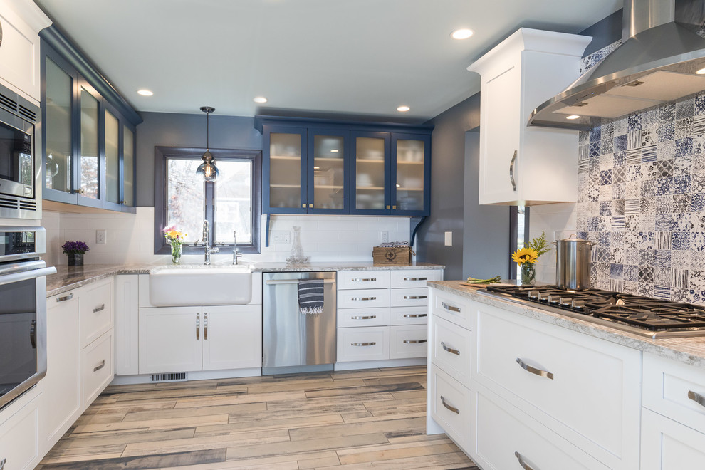 This is an example of a mid-sized traditional galley kitchen pantry in Manchester with a farmhouse sink, shaker cabinets, blue cabinets, quartz benchtops, blue splashback and multi-coloured floor.